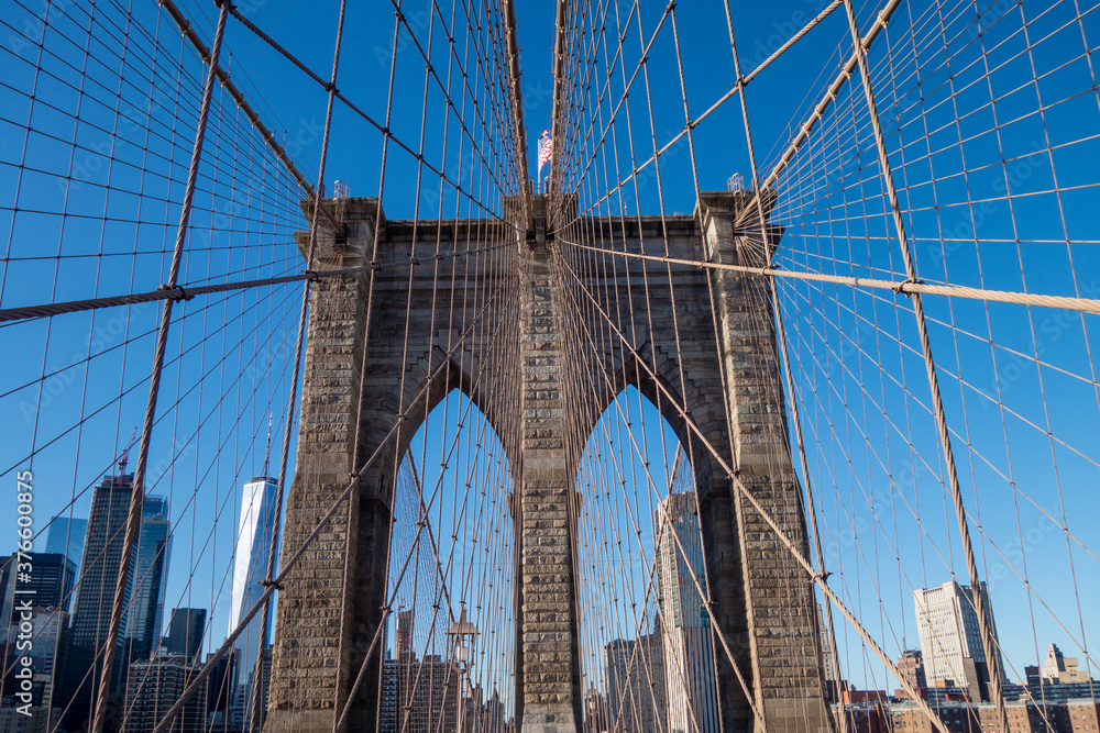 Fototapeta premium New york city manhattan to brooklyn bridge with use flag on top sand suspension cables