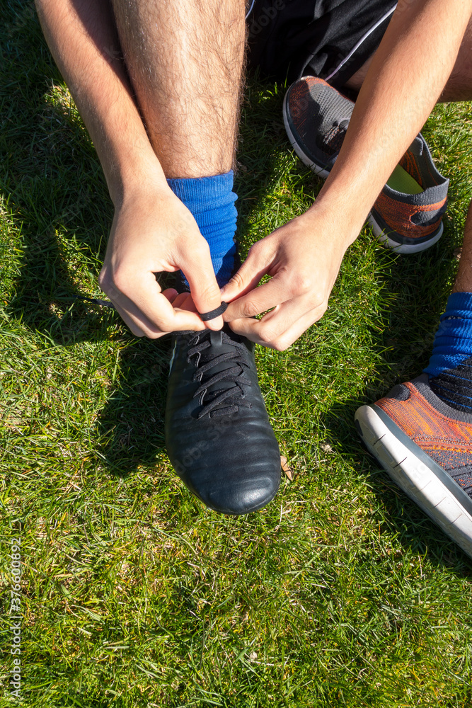 Soccer European football player putting on black cleats Stock Photo