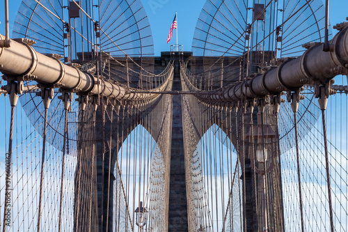 New york city manhattan to brooklyn bridge with use flag on top sand suspension cables