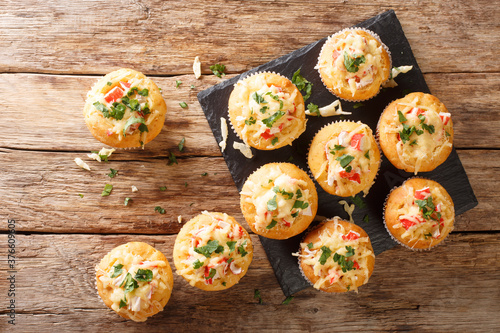 American snack corn muffins stuffed with crab herbs and cheese close-up on a slate board on the table. horizontal top view from above