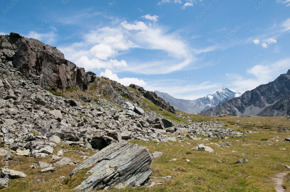 Landscape view of a plateau covered with grass and boulders in the Valley of the Seven Lakes. Russian Federation, the Altai Republic Landscape view of a plateau covered with grass and boulders in the Valley of the Seven Lakes. Russian Federation, the Altai Republic