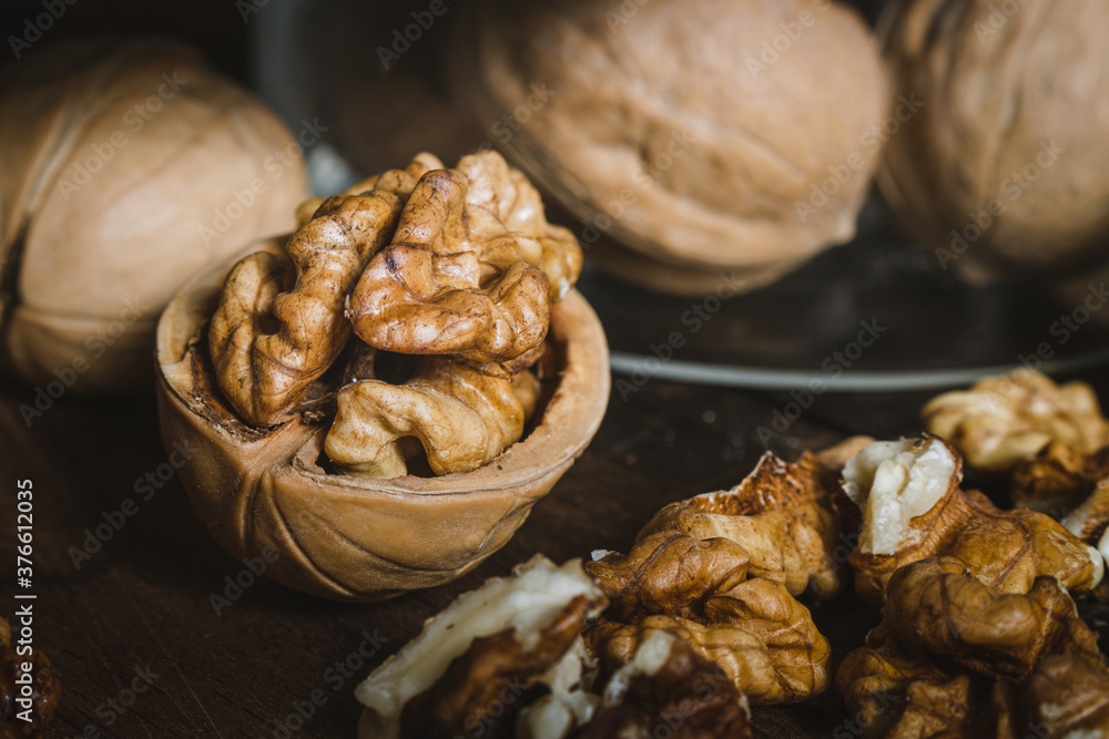 Fototapeta premium Walnuts on the table with bank closeup