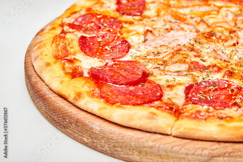 Pizza with salami, bacon and cheese on a light background. Close-up, selective focus