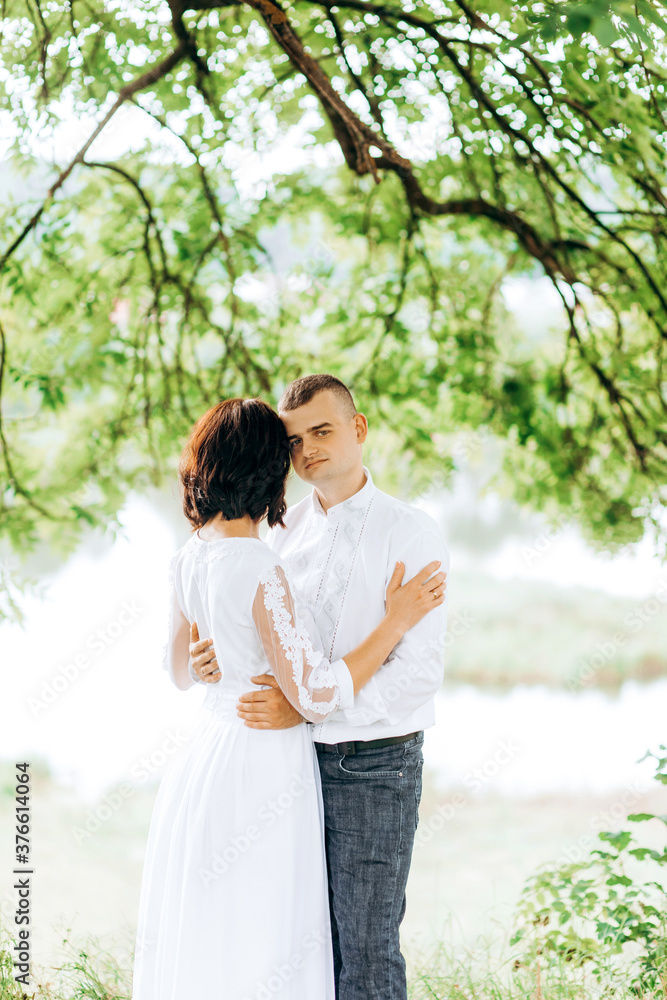 Attractive happy couple in love hugging. Man embracing tender woman. Attractive happy couple in love hugging. Man embracing tender woman.