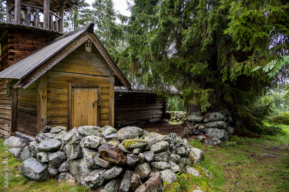 Naklejka premium wooden ancient church on the island among the trees during the rain