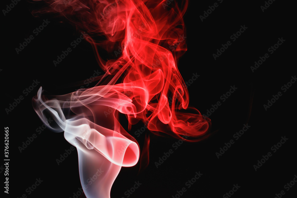 Fototapeta premium Red smoke on a black background. Colored smoke. Incense stick smoke, illuminated by red light.