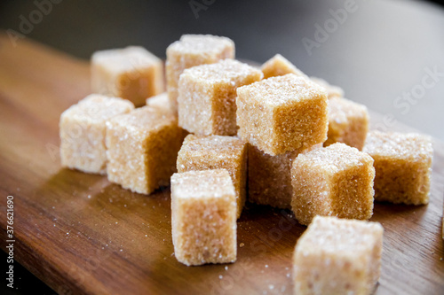 Brown cane sugar cubes on a cutting board