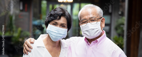 senior asian couple wearing face mask or face covering, concept social distancing, new normal lifestyle, protective health care; banner format