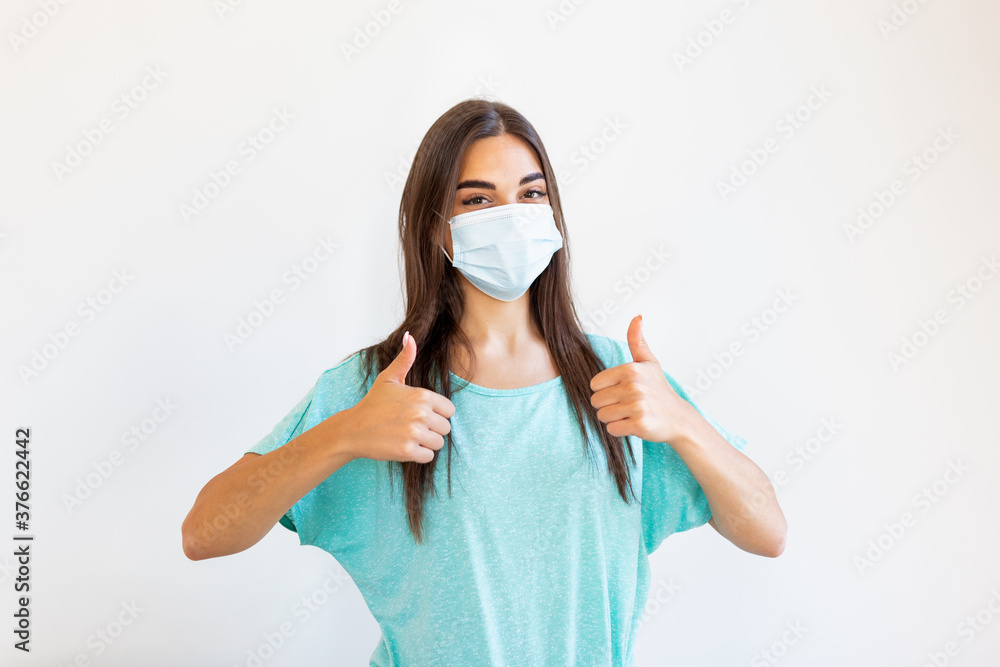 Portrait of young woman wearing face protective mask to prevent Coronavirus and anti-smog. Portrait of young woman wearing face mask. Thumb up. Portrait of young woman wearing face protective mask to prevent Coronavirus and anti-smog. Portrait of young woman wearing face mask. Thumb up.