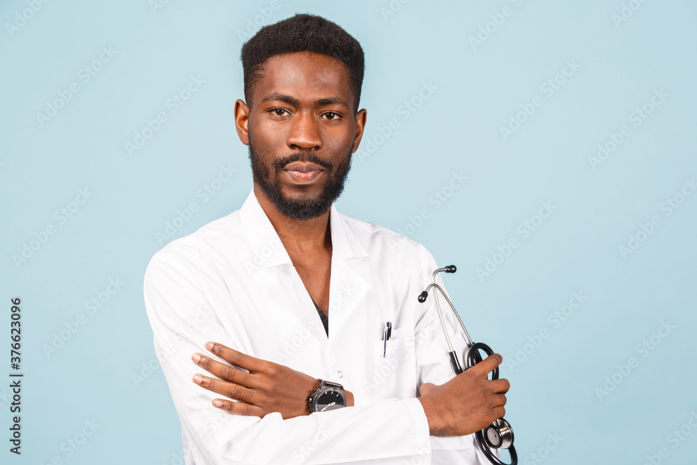 medicine, profession and healthcare concept. African american male doctor with stethoscope in white coat on blue background medicine, profession and healthcare concept. African american male doctor with stethoscope in white coat on blue background