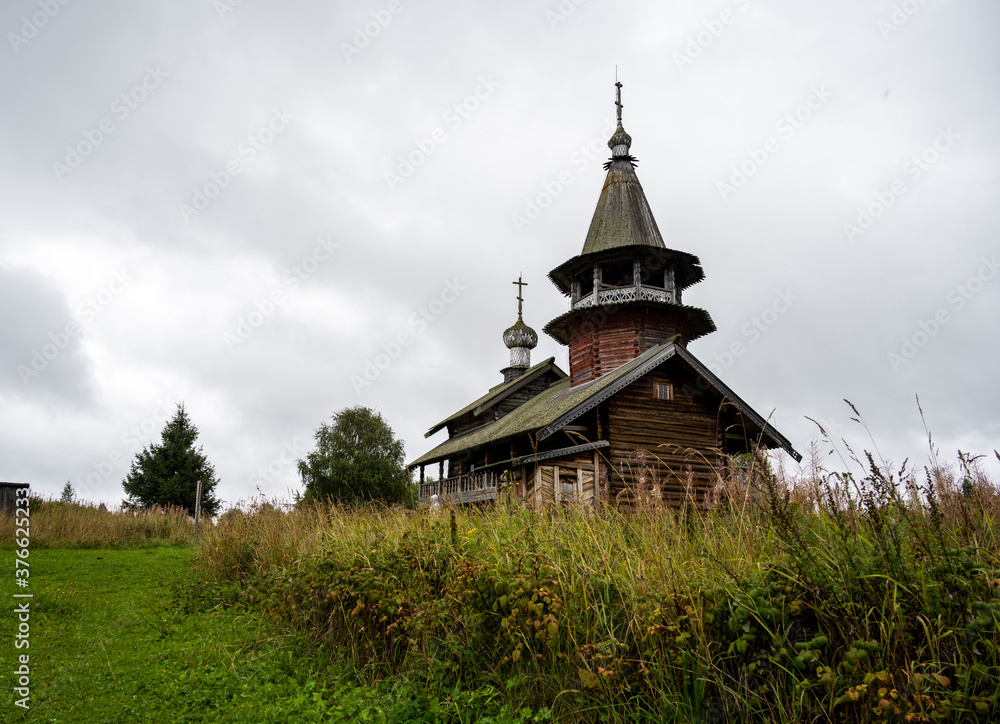 wooden ancient church on the island among the trees during the rain