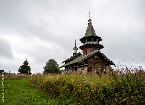 wooden ancient church on the island among the trees during the rain