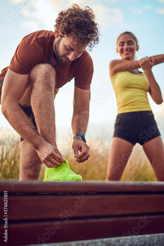 Young adult sporty couple working out outdoors.