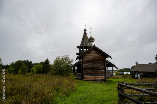 wooden ancient church on the island among the trees during the rain