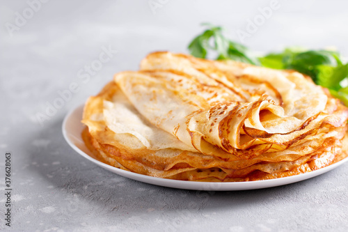 Thin homemade pancakes. Light background. Beautiful and delicious breakfast at home or in the cafe.
