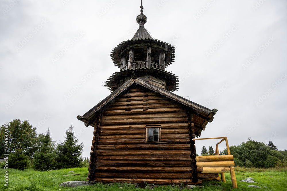 wooden ancient church on the island among the trees during the rain