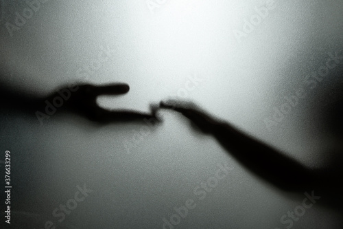 Ghost concept shadow of hand behind the matte glass blurry hand and body soft focus.