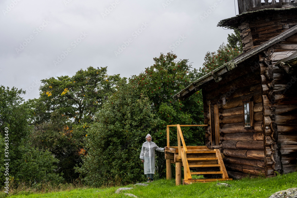 a woman in a white raincoat gets acquainted with the sights on an island where no one else lives a woman in a white raincoat gets acquainted with the sights on an island where no one else lives