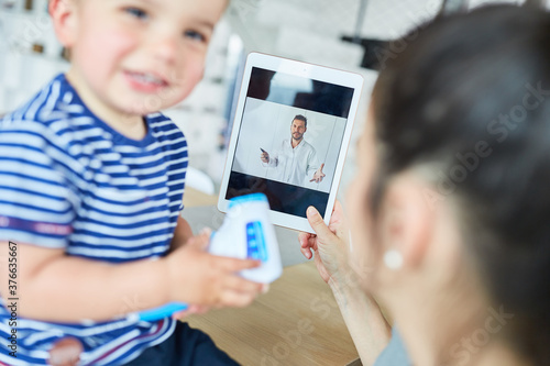 Mutter mit Kind im Videochat mit einem Kinderarzt