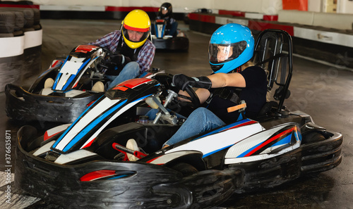 Adult woman driving sport car for karting in a circuit lap in sport club