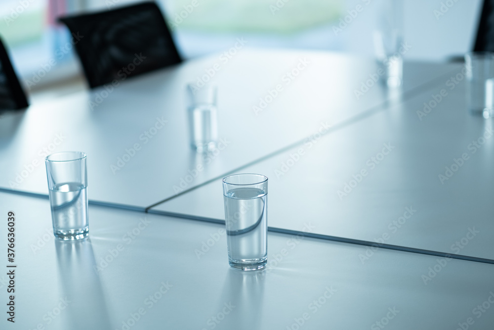 Volle Gläser mit Mineralwasser auf einem Besprechungstisch Volle Gläser mit Mineralwasser auf einem Besprechungstisch