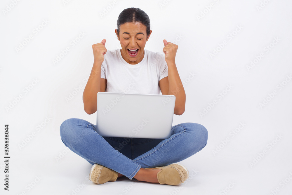 Caucasian brunette woman rejoicing her success and victory clenching her fists with joy. Lucky woman being happy to achieve her aim and goals. Positive emotions, feelings. Caucasian brunette woman rejoicing her success and victory clenching her fists with joy. Lucky woman being happy to achieve her aim and goals. Positive emotions, feelings.