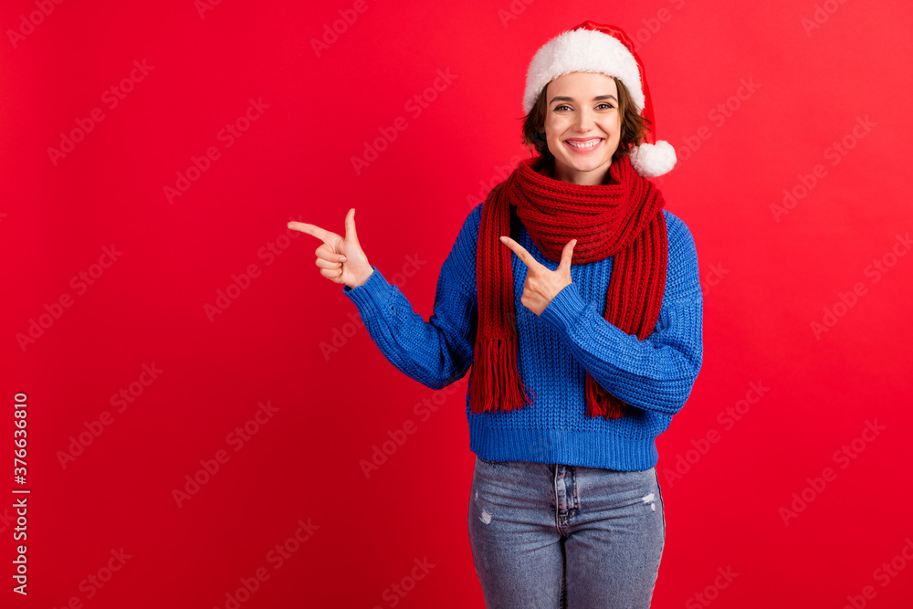 Photo of positive girl in santa claus cap point index finger demonstrate christmas tradition magic discount wear blue knitted pullover jeans isolated over bright shine color background