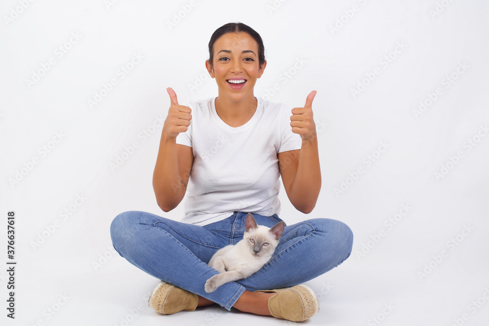Φωτογραφία Closeup of young optimistic female isolated on grey background showing thumbs up with positive emotions of content and happiness