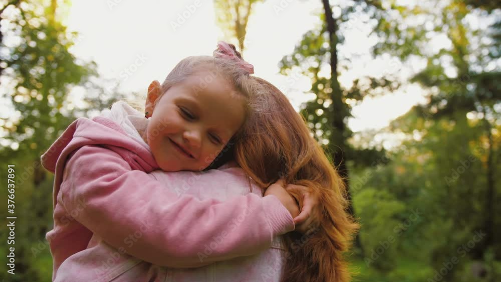 Little daughter hugging mother with eyes closed, happy affectionate family