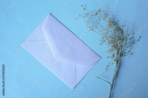 white envelope with dried grass for greeting mockup seasonal concepts on blue background