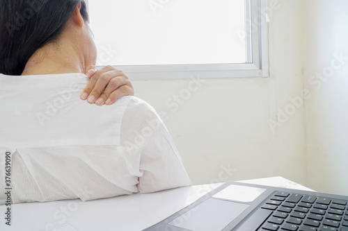 Woman sitting working Shoulder pain.