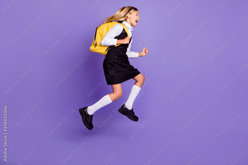Full length body size view of nice attractive cheerful purposeful energetic small little girl jumping running first lesson isolated bright vivid shine vibrant lilac violet purple color background Full length body size view of nice attractive cheerful purposeful energetic small little girl jumping running first lesson isolated bright vivid shine vibrant lilac violet purple color background