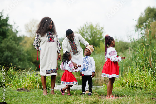 African family in traditional clothes at park.