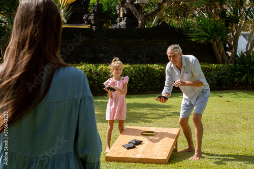 Canvastavla Happy family playing cornhole game outdoor on sunny summer day