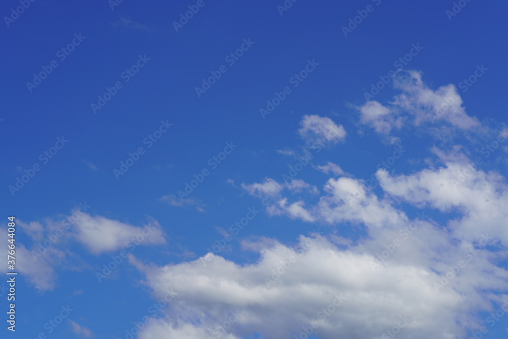 sunny day with white clouds on the blue sky