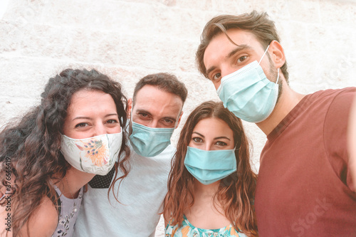 Friends group having fun taking a selfie and wearing the surgical mask.