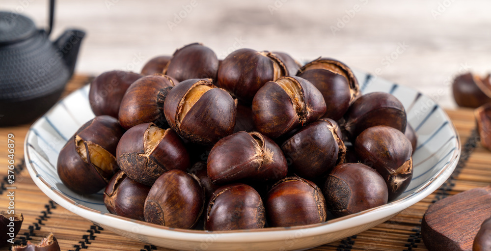 Delicious cut roasted chestnuts with oil and sugar, healthy eating snack in life, close up. Delicious cut roasted chestnuts with oil and sugar, healthy eating snack in life, close up.