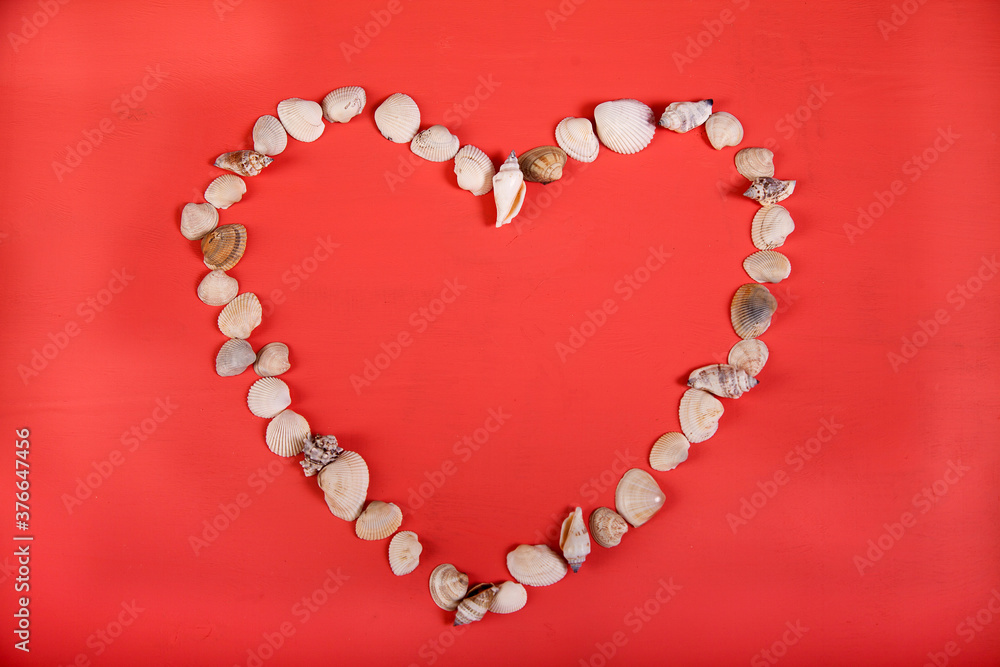 Heart-shaped seashells lie on a pink background. Copy spaes. Heart-shaped seashells lie on a pink background. Copy spaes.