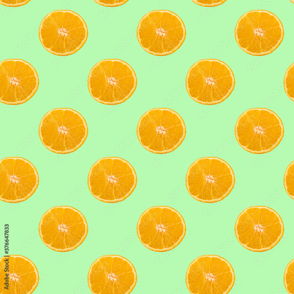 A pattern of sliced orange circles on a light green background. A pattern of sliced orange circles on a light green background.