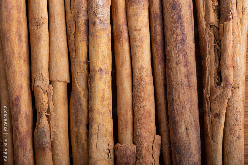 Cinnamon sticks in row as background. Top view, close-up. Cinnamon sticks in row as background. Top view, close-up.