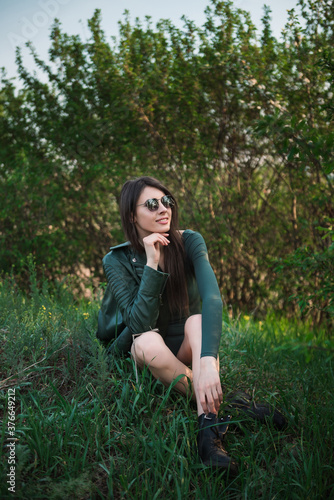 Beautiful Young Woman sit on the grass.