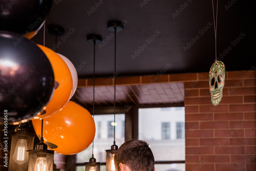 Electric lamps and balloons as Halloween decor in a cafe