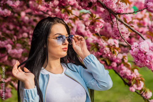 Woman fancy sunglasses in spring flower bloom. Girl in cherry blossom flower. Spring fashion collection. Sakura tree blooming. Soft and tender. Sakura suits her. Gorgeous flower and female beauty