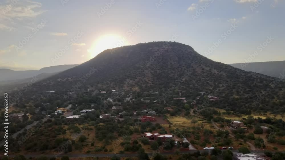 Aerial of morning sunrise coming over mountain rock in Sedona, Arizona, sun rays shinning through landscape Aerial of morning sunrise coming over mountain rock in Sedona, Arizona, sun rays shinning through landscape