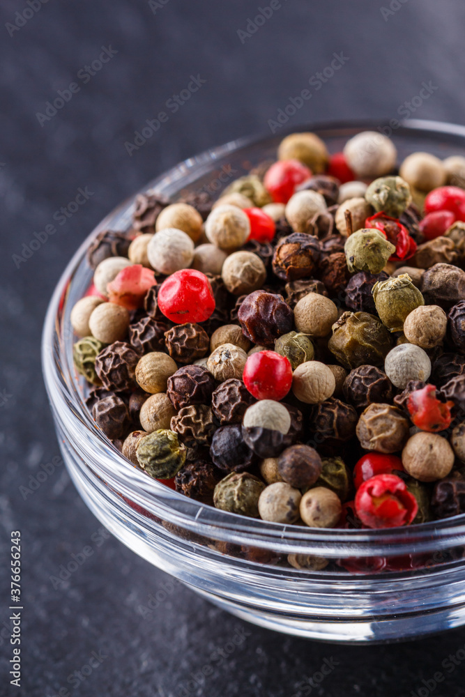 mix of peppercorns on a dark stone background mix of peppercorns on a dark stone background