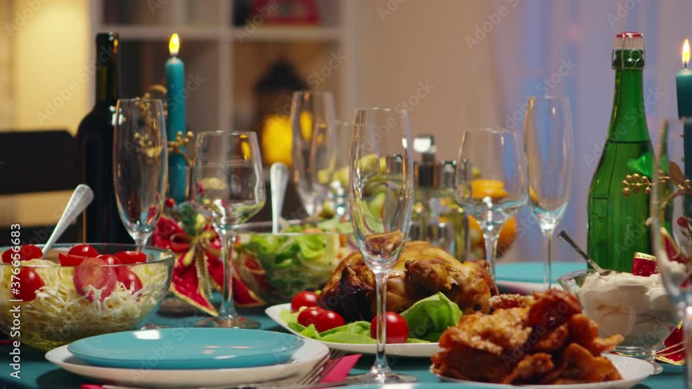 Traditional food for christmas celebration of friends. Candles on the table. Xmas celebration in decorated room full of globe decorations and christmas tree with fireplace, big festive dinner meal for Traditional food for christmas celebration of friends. Candles on the table. Xmas celebration in decorated room full of globe decorations and christmas tree with fireplace, big festive dinner meal for
