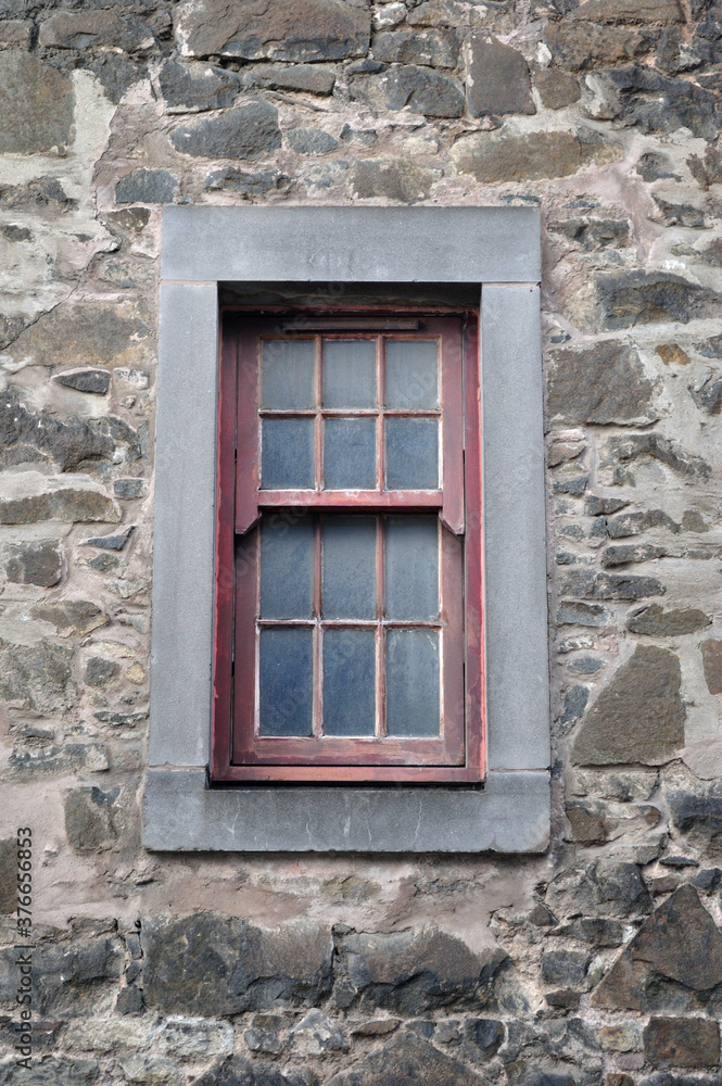 Old Dirty Window with Stone Frame & Rough Textured Stone Wall 