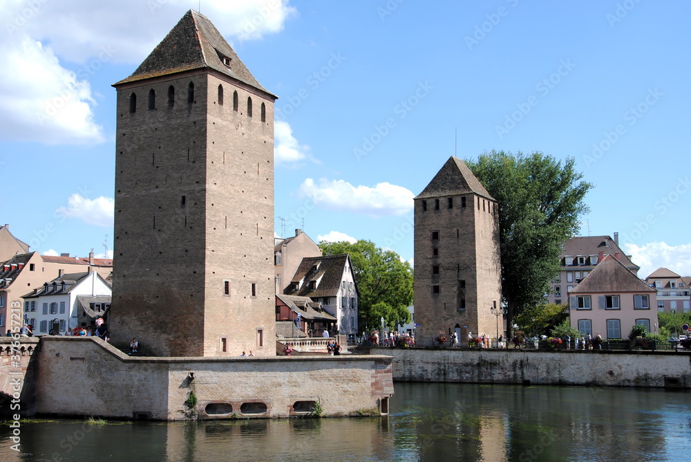 View on the towers and bridges of the Ponts Couverts (Covered Bridges) that cross the four river channels of the River Ill flowing through Strasbourg's historic Petite France quarter. 