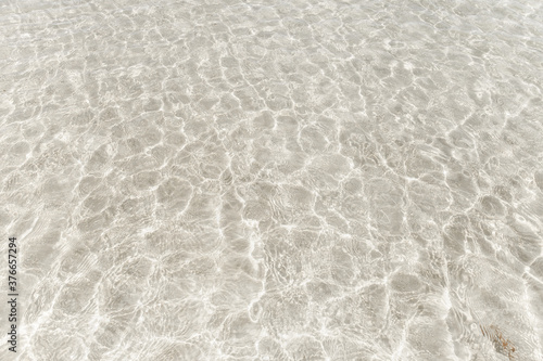 Tableau sur toile Top view surface of clear sea water reflections on shallow sandy beach