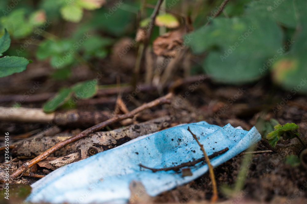 Closeup shot of a dirty used medical mask on the ground Closeup shot of a dirty used medical mask on the ground
